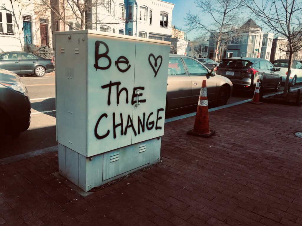 Be the change spray-painted on concrete in a city neighborhood