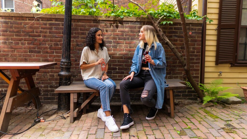 Two women talking outside on a restaurant patio