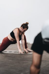 Woman practicing yoga in a studio, demonstrating a gentle pose suitable for light movement. Ideal for people managing autoimmune conditions who are looking for low-impact exercise options.