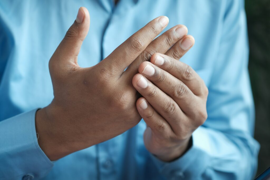 Man holding painful joints in fingers and hands