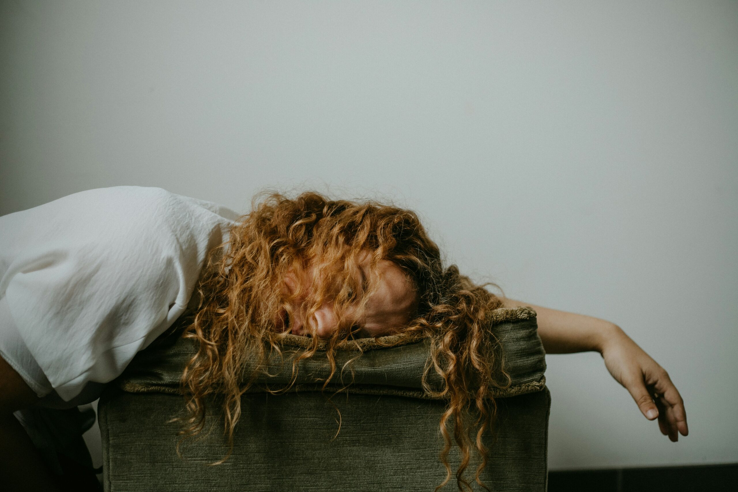 Young woman resting her head on her arm, asleep on a box, illustrating midday fatigue and the need for simple strategies to overcome the afternoon energy crash.